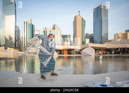 Abu Dabi, United Arab Emirates, 14th December 2019: fisherman demonstrating how fish net needs to be thrown Stock Photo