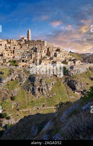 Long view across 'la Gravina' ravine to the Sassi of Matera at sunrise, Basilicata, Italy. A UNESCO World Heritage site.  The area of Matera has been Stock Photo