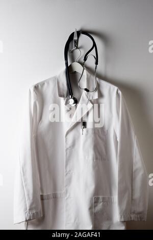 Doctor's coat hanging on a coat hanger on a coat rack, with a ...