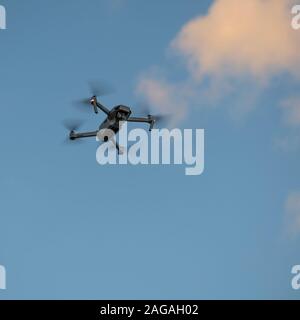 Drone in flight taking pictures. Stock Photo