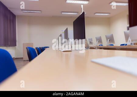Modern office with computers on desks. Empty computer room in college. Interior of classroom with computers. Concept of corporate working space. Stock Photo