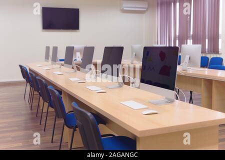 Modern office with computers on desks. Empty computer room in college. Interior of classroom with computers. Concept of corporate working space. Stock Photo