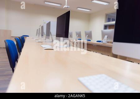 Modern office with computers on desks. Empty computer room in college. Interior of classroom with computers. Concept of corporate working space. Stock Photo