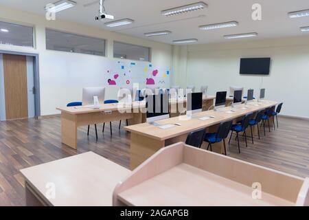 Modern office with computers on desks. Empty computer room in college. Interior of classroom with computers. Concept of corporate working space. Stock Photo