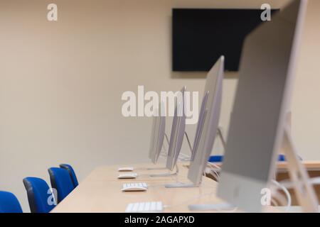 Modern office with computers on desks. Empty computer room in college. Interior of classroom with computers. Concept of corporate working space. Stock Photo