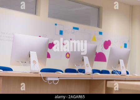 Modern office with computers on desks. Empty computer room in college. Interior of classroom with computers. Concept of corporate working space. Stock Photo