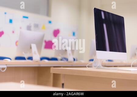 Modern office with computers on desks. Empty computer room in college. Interior of classroom with computers. Concept of corporate working space. Stock Photo