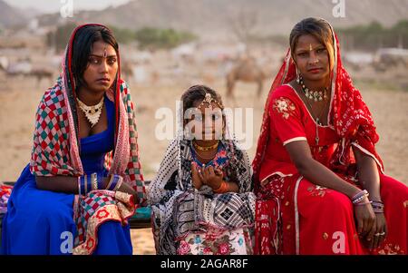 Portrait of Gypsy entertainers in traditional colorful clothes at dusk at the camel fair at Pushkar, Rajasthan, India. Stock Photo