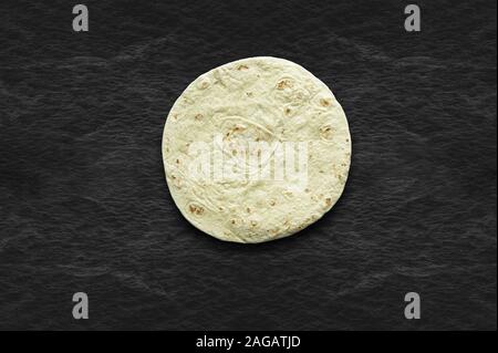 Overhead shot of a tortilla bread on a black surface Stock Photo