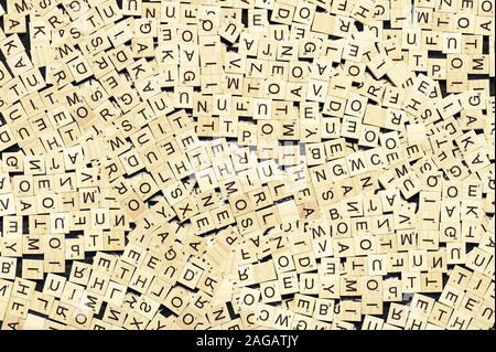 Overhead shot of wordplay wooden cubes scattered on a dark surface Stock Photo