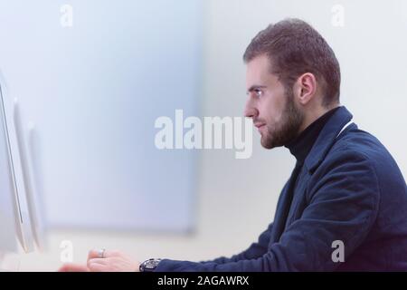 Young male Businessman working on modern computer. Businessman using innovative technologies. Businessman working on computer, software developing wit Stock Photo