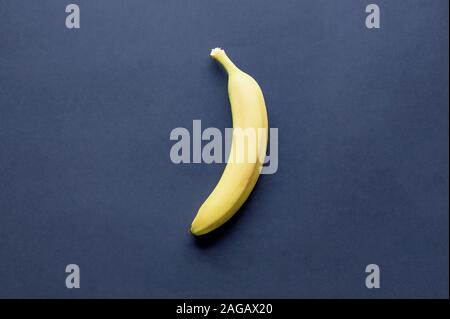 Overhead shot of a single banana on a blue surface Stock Photo