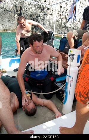 Diving accident, diver subserve the victim with pure oxygen on a dive boat, Limni Keriou, Zakynthos island, Greece Stock Photo
