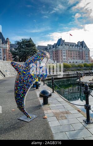 A vertical shot of a street decoration in the form of a dolphin at the Victoria Inner Harbour in Victoria, BC Canada
