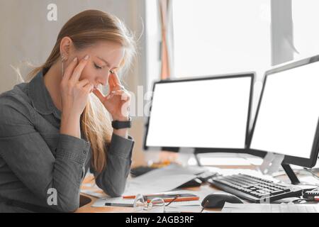 Exhausted woman working in an office before the deadline. Close up photo. Stock Photo