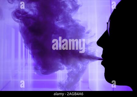 Man with electronic cigarette and smoke vapping with neon lights background help quit smoking tobacco Stock Photo