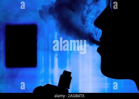 Man with electronic cigarette and smoke vapping with neon lights background help quit smoking tobacco Stock Photo