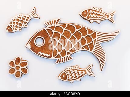 Cute hand painted gingerbread fish cookies on a white background. Set of ornate traditional Christmas and New Year sweet pastries decorated with icing. Stock Photo