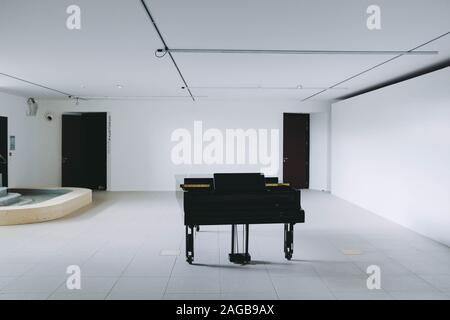 Black piano standing in a room with a minimalistic interior Stock Photo