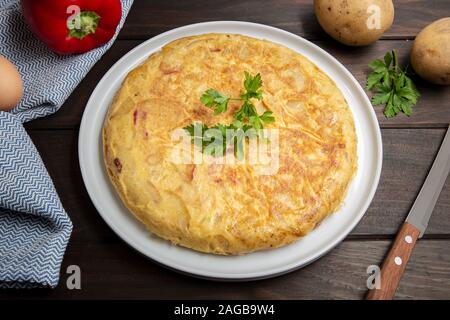 Spanish potato omelette called spanish tortilla. Omelet recipe with potato, egg, onion and red pepper Stock Photo