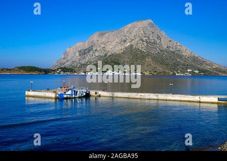 Blue and white taxi-boat, Calm blue morning at Myrties Jetty, Kalymnos Greece. Telendos in the distance. Stock Photo