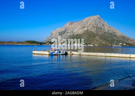 Blue and white taxi-boat, Calm blue morning at Myrties Jetty, Kalymnos Greece. Telendos in the distance. Stock Photo