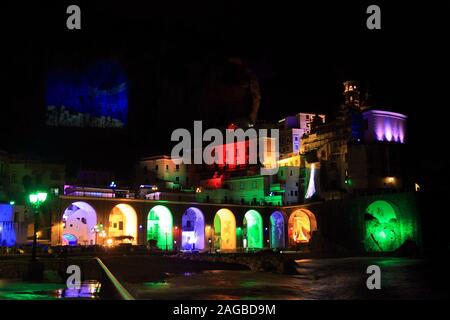 Colorful houses and arches with Christmas lights seen from the beach of the seaside town of the Amalfi Coast Stock Photo