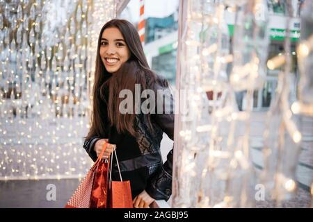 Woman entering at outside cafe with shopping bags Stock Photo