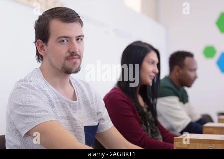 Group of students study  in modern school computer lab classroom. Male student looking into camera. Stock Photo