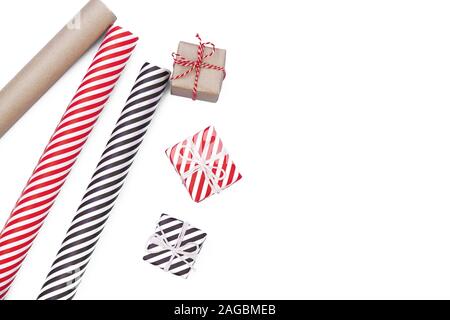 Flat lay with christmas present and wrapping paper on white background. Gift boxes wrapped in a paper. Christmas xmas or New year gift packing. Holiday decor concept Stock Photo