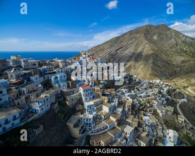 High shot of modern white buildings in Karpathos surrounded by mountains and sea in the background Stock Photo