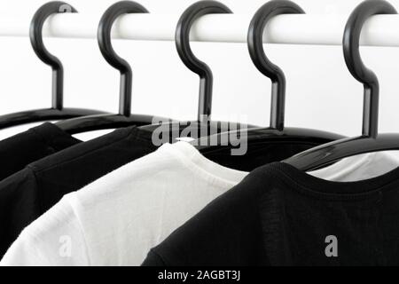 black and white color tone clothes on hangers in wardrobe. Woman minimalist wardrobe. Horizontal banner Stock Photo