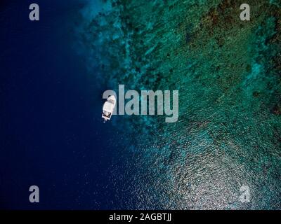 Aerial shot of a boat on the beautiful blue ocean in Bonaire, Caribbean Stock Photo