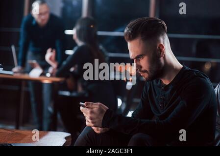 Worrying about results. Team of young business people works on their project at night time in the office Stock Photo