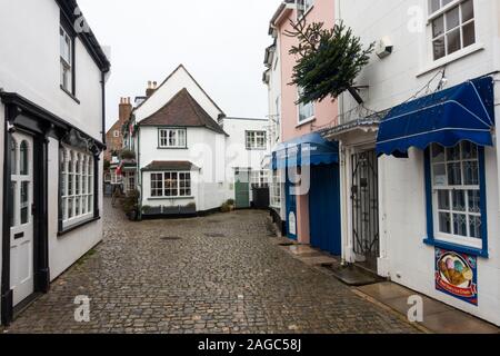 Quaint old shops & buildings on a cobbled street in December, Lymington, Hampshire, England, UK Stock Photo