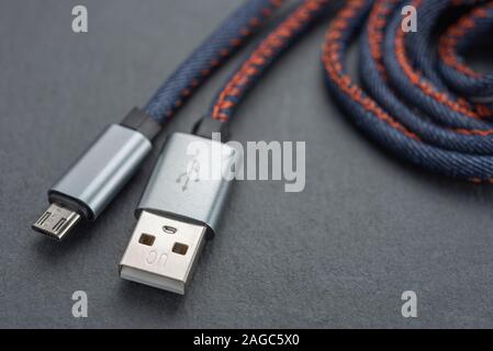 Micro USB cable with cable against a dark background.. Stock Photo