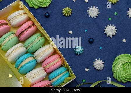 Tasty multi-colored sweet macaroons in a white gift box on a classic blue background, Top view Stock Photo