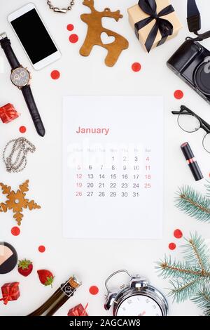 january calendar page, digital camera, alarm clock, smartphone, champagne bottle, cosmetics, glasses, fir branch, fresh strawberry,  christmas baubles Stock Photo