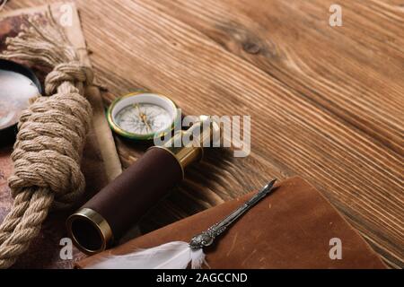 rope cable, nib, compass and telescope on wooden surface Stock Photo