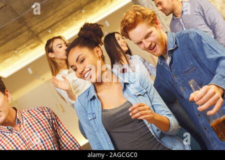 Group of friends having party indoors fun together moving cheerful Stock Photo