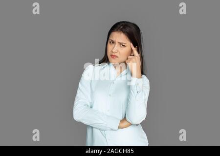 Freestyle. Young woman standing isolated on grey scratching face concerned Stock Photo