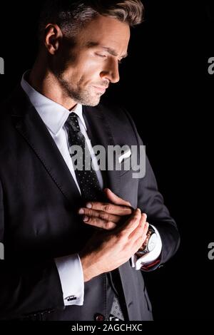 Side view of thoughtful businessman looking down isolated on black Stock Photo