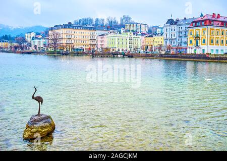 GMUNDEN, AUSTRIA - FEBRUARY 22, 2019: The small sculpture of the heron standing on the boulder on Traunsee lake, on February 22 in Gmunden Stock Photo