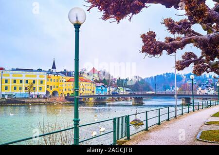 GMUNDEN, AUSTRIA - FEBRUARY 22, 2019: Walk along the bank of Traunsee lake watching architecture of old town and birds, floating through the lake, on Stock Photo
