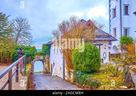 The small old house with tiny garden and the arch leading to the bank of Traun lake in sleepy Traunkirchen village, Austria Stock Photo