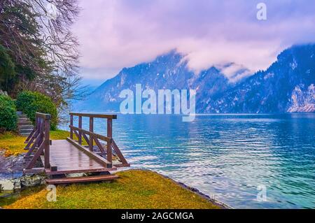 The tiny bridge at Badeinsel recreational zone with a view on Traunsee lake and rainy clouds, stuck on Traunstein mountain, Traunkirchen, Salzkammergu Stock Photo