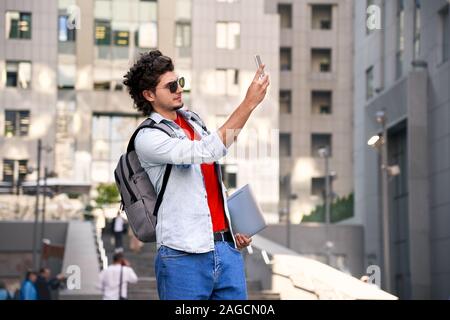 Young adult guy making photo on smartphone Stock Photo