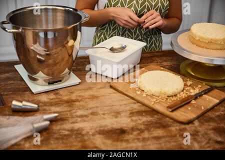 Selective focus of confectioner standing at table with ingredients for baking Stock Photo