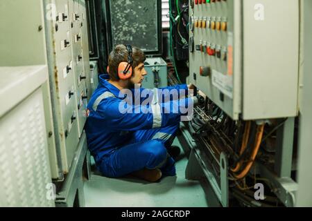 Marine engineer inspecting ship's engine or generators Stock Photo