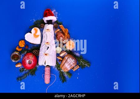 Christmas tree made of wine, cheese, prosciutto and fruit. blue background. View from above. The concept of Christmas and New Year holidays. For postcards Stock Photo